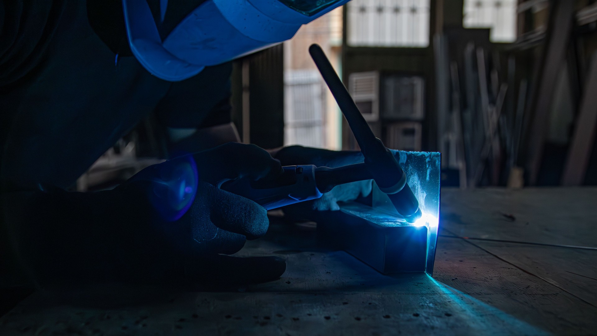Close-Up of Welding Torch and Sparks with Blue Protective Mask